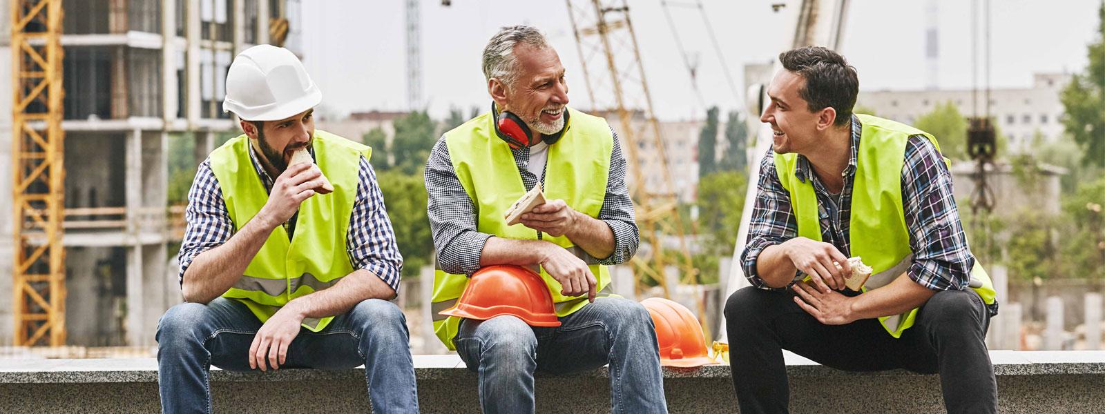 Happy tradespeople eating sandwiches